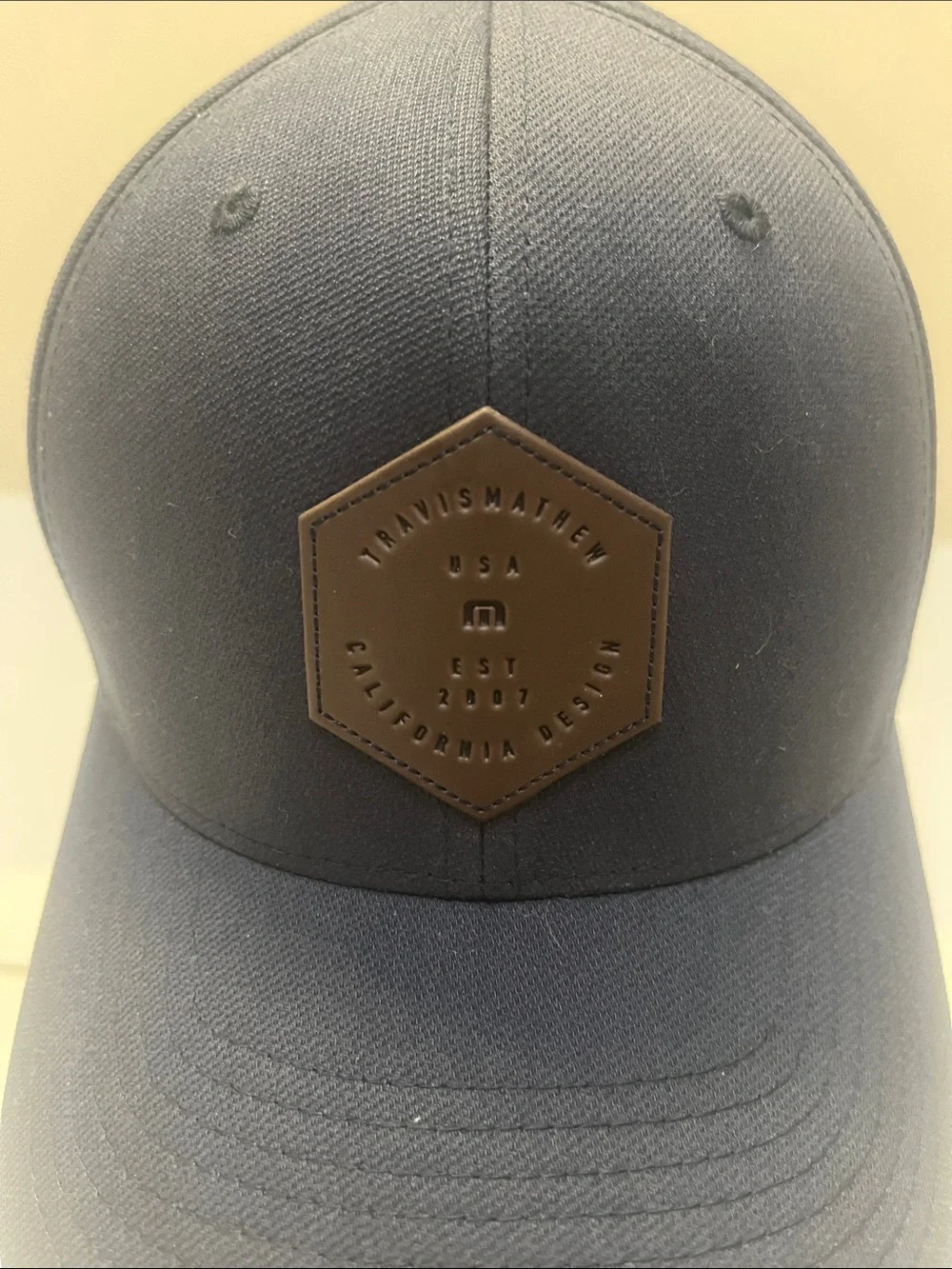 Travis Mathew Navy Blue Baseball Cap with Brown Hex Patch